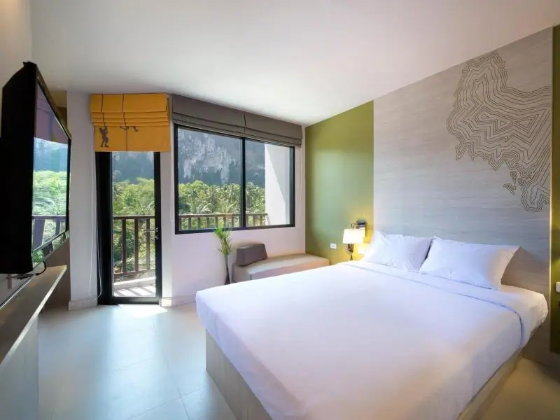 Simple twin-bed hotel room with a window looking outside