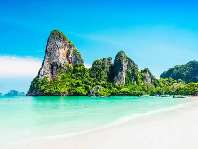 Limestone karsts rising above a pale sand beach