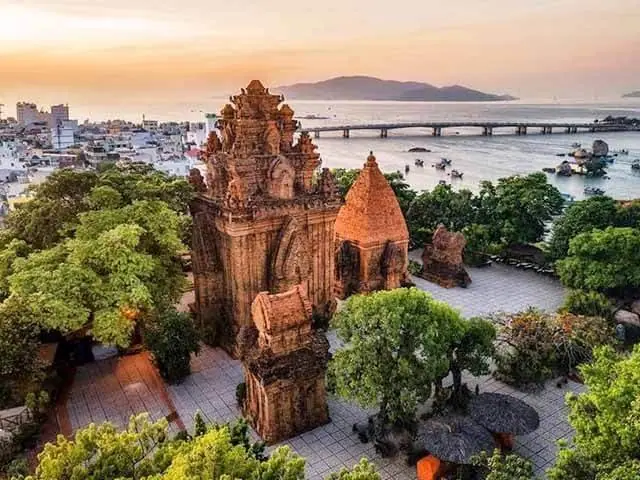 Brick Cham towers on a rise above a coastal city, seen from the air