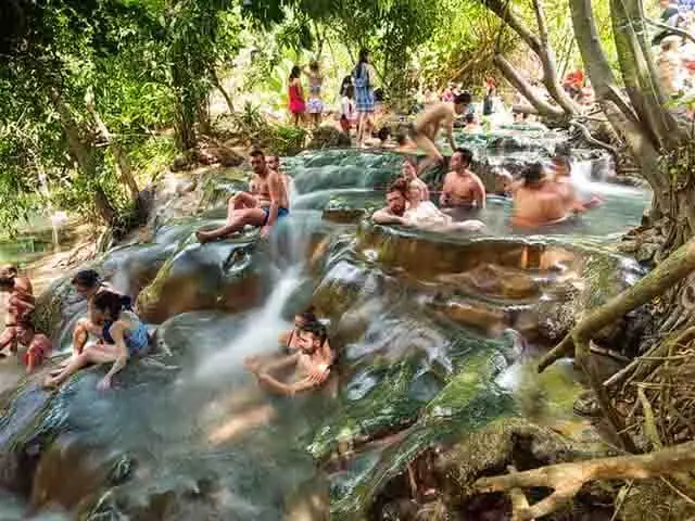 Bathers in the thermal limestone basins of the Hot Spring Waterfalls, Krabi