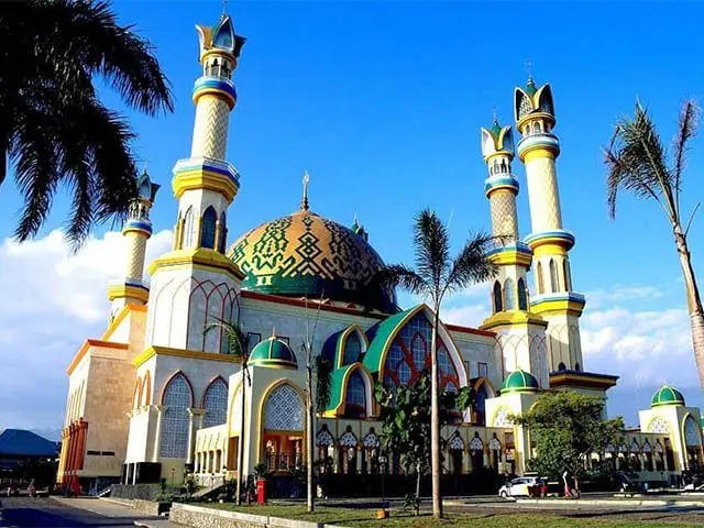 An Indonesian mosque with minarets rising above the palms