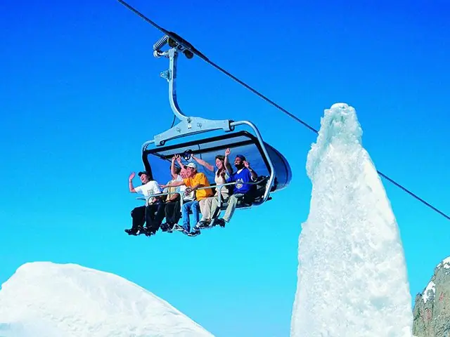 Friends riding a chairlift above the snow